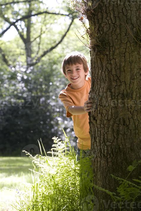 Boy 8 10 Peeking Out From Behind Tree Smiling Portrait 864988 Stock