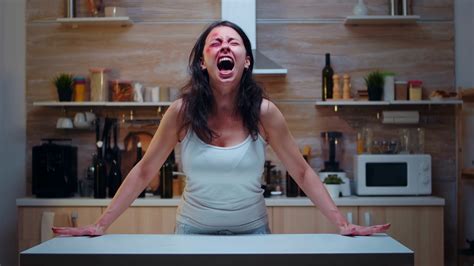 Woman Victim Screaming And Crying Desperately Sitting In The Kitchen