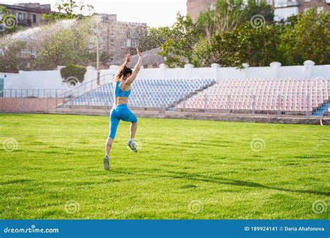 Woman Athlete Leaping Somersault On The Stadium Doing Exercises
