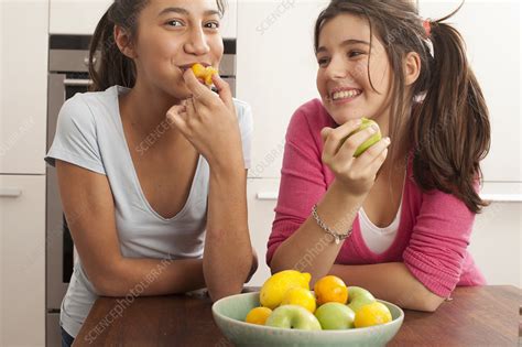 Teenage Girls Smiling Eating Fruit Stock Image F0037113