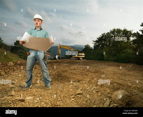 Young Caucasian Architect Standing On Construction Site Holding