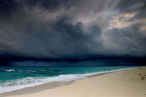 Storm Clouds Over The Ocean And Beach With Footprints In The Sand