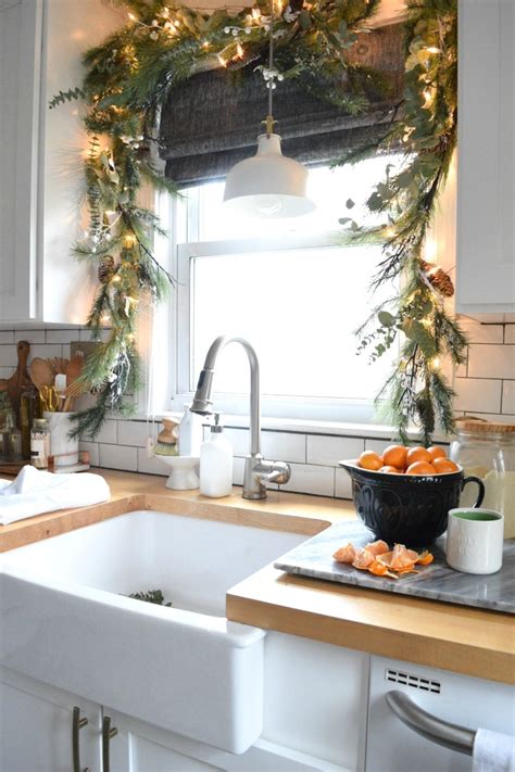 Evergreen garlands placed right on the shelves add a rustic and natural feel to the kitchen. Christmas in our Small Kitchen- Started with Christmas Garland - Nesting With Grace