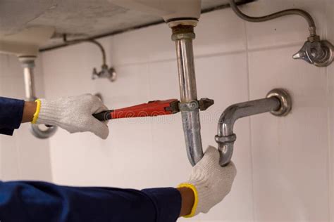 Plumber Fixing White Sink Pipe With Adjustable Wrench Stock Photo