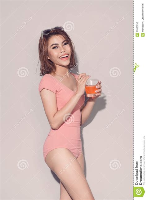 Asian Attractive Brunette Woman Drinking Orange Juice Posin Stock Photo