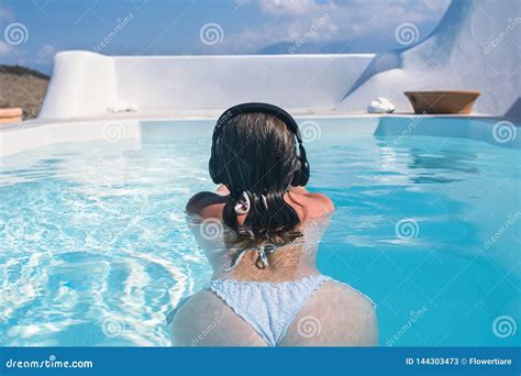 woman in the headphones listening to the music bathing in a pool stock image image of relaxe