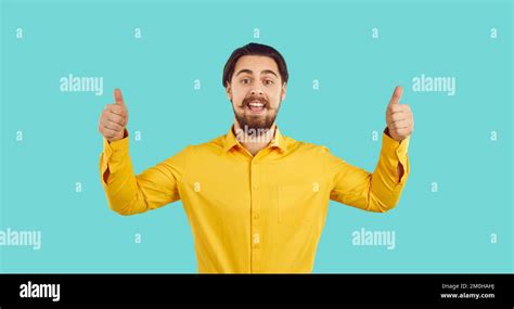 Portrait Of Happy Cheerful Handsome Young Man Showing Thumbs Up With
