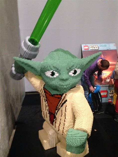 A Lego Star Wars Yoda Holding A Green Plastic Object