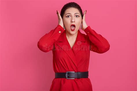 Indoor Portrait Of Surprised Impressed Good Looking Brunette Raising Her Arms Opening Mouth And