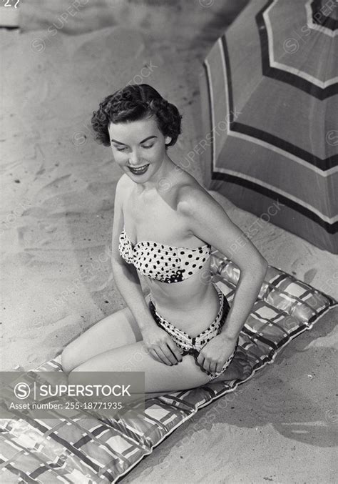 Vintage Photograph Woman Smiling In Swimsuit Sitting On Mat In Sand Model Released Superstock
