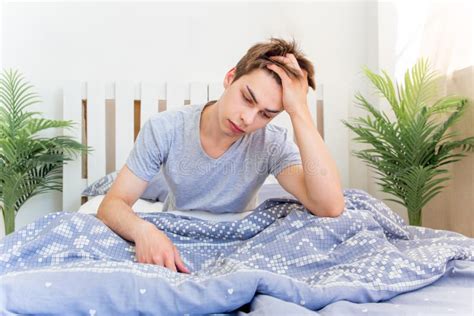 A Young Man Waking Up In Bed In The Morning Stock Photo Image Of