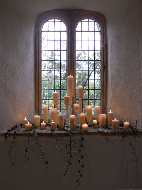 A Glowing Candle Display Decorated With Simple Ivy Church Candles