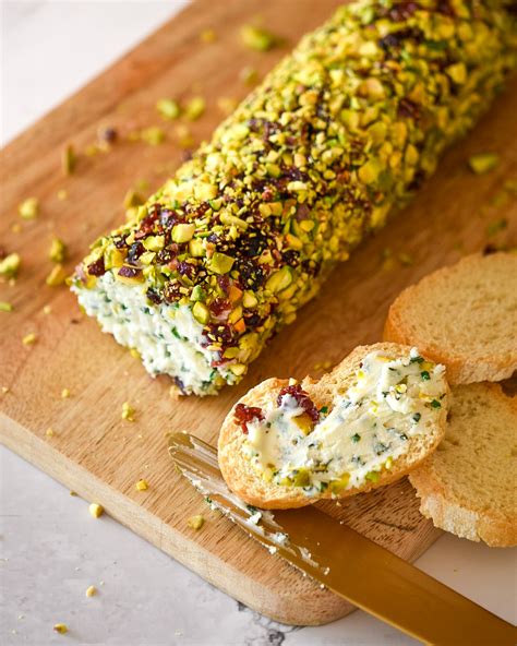 Rulo de queso de cabra con pistachos arándanos y hierbas aromáticas