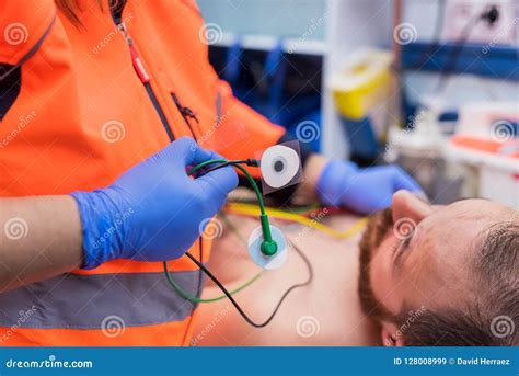 Emergency Doctor Hands Attaching Ecg Electrodes On Patient Chest In