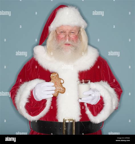 Santa Claus Holding Cookie And Milk Stock Photo Alamy
