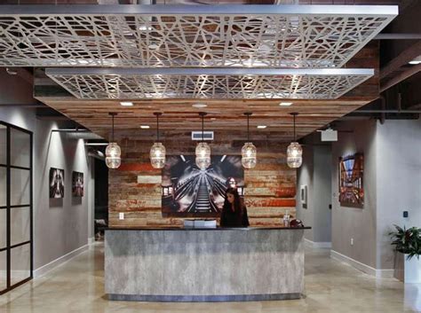 An Office Lobby With Wooden Paneling And Metal Accents On The Ceiling