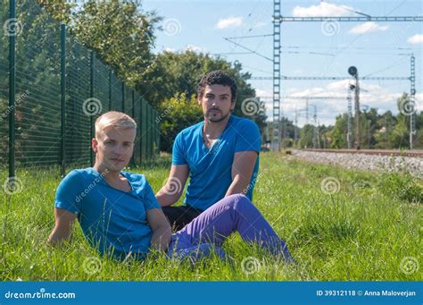 Twee Kerels Die In Een Gras Zitten Stock Foto Image Of Modern Buiten