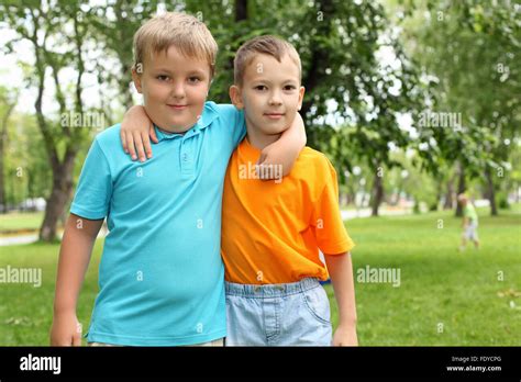 Two Boys Standing Next To Each Other In The Summer Park Stock Photo Alamy