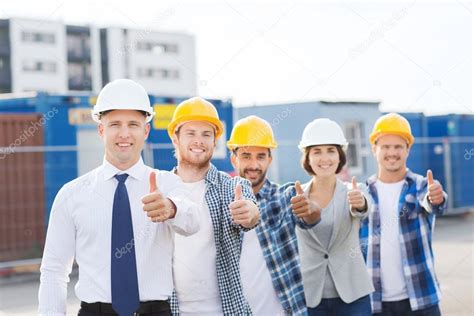 Group Of Smiling Builders In Hardhats Outdoors — Stock Photo © Syda