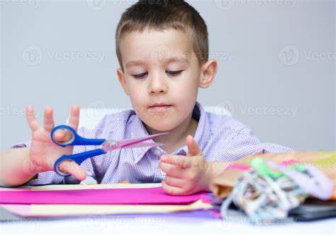 Boy Is Cutting Paper Using Scissors 988116 Stock Photo At Vecteezy