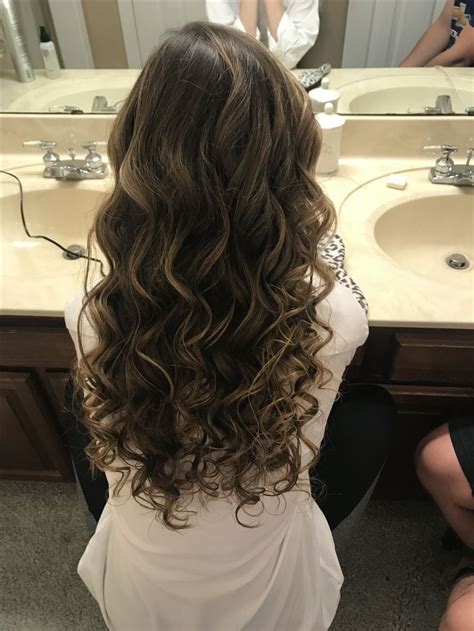 Medium length curly hair styled in a cool ponytail with some fringes let loose on front. Homecoming hair #curls #homecoming #prom #highlights # ...