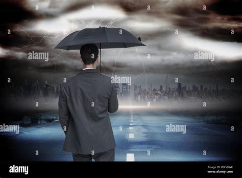 Rear View Of Classy Businessman Holding Grey Umbrella Against Stormy