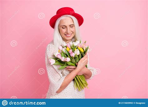 Portrait Of Attractive Dreamy Cheerful Grey Haired Elderly Granny Holding Smelling Floral Fresh