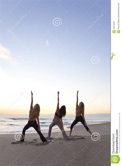 Tres Mujeres Que Practican Yoga En La Playa En La Salida Del Sol Imagen