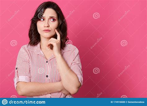 Indoor Shot Of Attractive Woman With Thoughtful Expression Keeps Hand