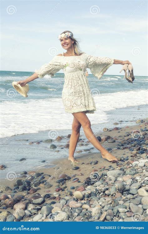 woman in white dress walking barefoot on the beach stock image image of happy sand 98360033
