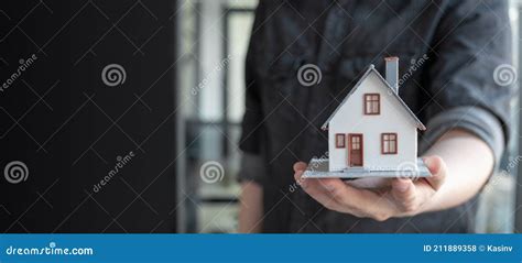 Man Holding House Model In Hand Real Estate Property Home Buying And