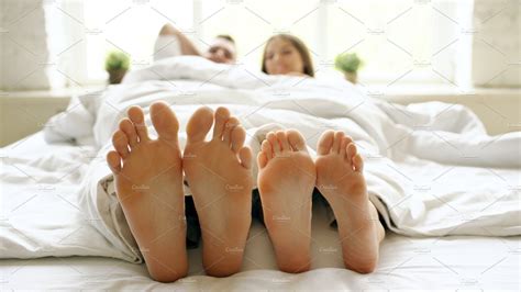 Closeup Of Young Beautiful And Loving Couple Play And Dance Their Feet Under Blanket While Wake