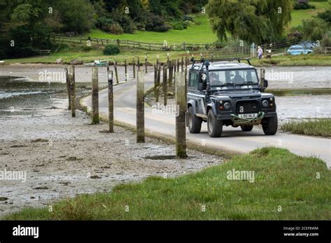 Land Rover Defender Driving On The Tidal Road Aveton Ford Stock
