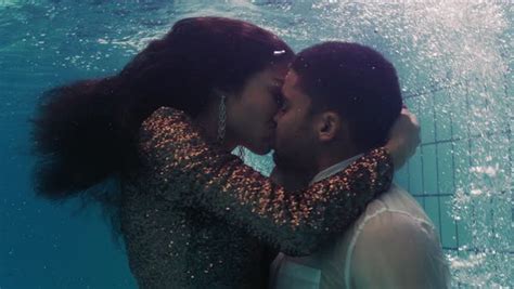 Romantic Couple Kissing Underwater In Swimming Pool Wearing Clothes