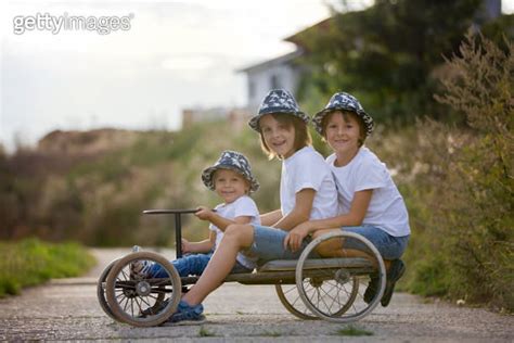 Happy children, boys, riding old retro car with four wheels 이미지