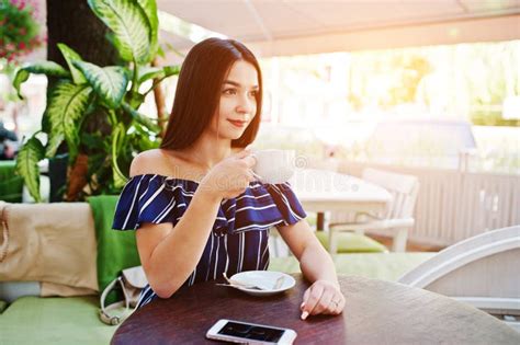 Gorgeous Brunette Girl Sitting On The Table In Cafe With Cup Of Coffee Stock Photo Image Of