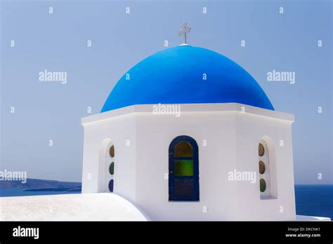 White Church With Blue Dome Against A Blue Sky In Oia Santorini Greece