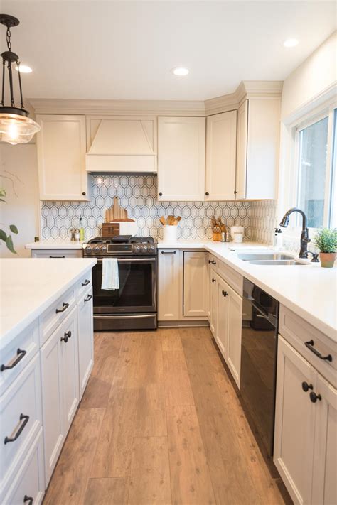 Especially those white melamine cabinets with the strip of oak on the bottom of each door. White Chef Kitchen With Patterned Gray Backsplash | HGTV