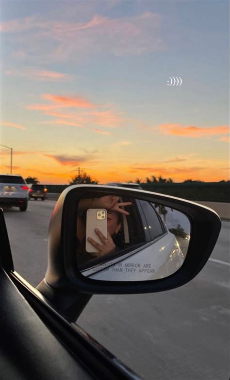 Someone Taking A Selfie In The Side Mirror Of A Car At Sunset Or Dawn