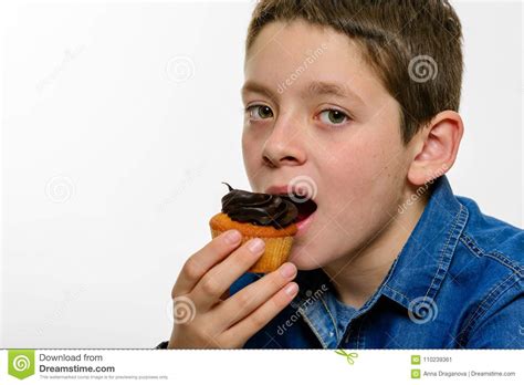 Young Boy With Denim Shirt Eatng Chocolate Cupcake On White Isolated