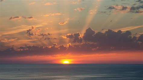 Download Wallpaper 1366x768 Sun Sunset Horizon Sea Clouds Tablet