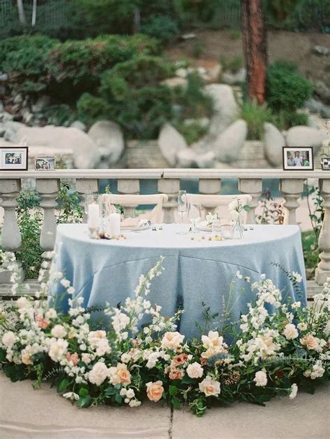 Sweetheart Table With Blue Linens And Clusters Of Fresh Flowers
