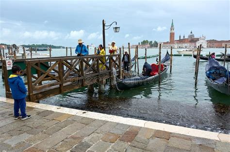 Tourists Disembarking From Gondola With San Giorgio Maggiore Church In