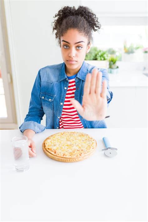 Young African American Woman Eating Homemade Cheese Pizza With Open Hand Doing Stop Sign With