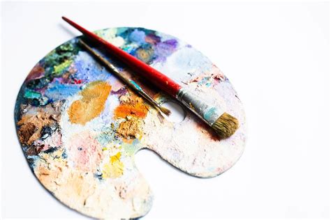 Colourful Painters Palette With Oil Paint And Brushes On White