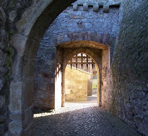An Alley Way With Stone Walls And Archways Leading To Another Building