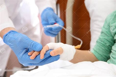 Doctor Adjusting Intravenous Drip For Little Child In Hospital Stock