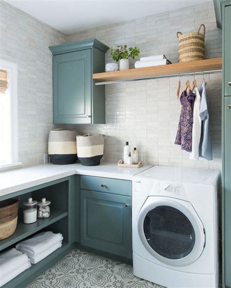 A new classic laundry room remodel with clay tiles, green cabinets, and