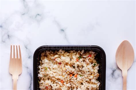 Delicious Fried Rice In Lunch Box With Wooden Spoon And Fork On Marble