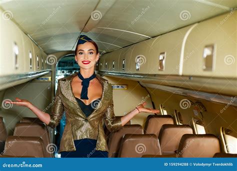 Beautiful Flight Attendant In An Airplane Cabin Smiling On A Board Of